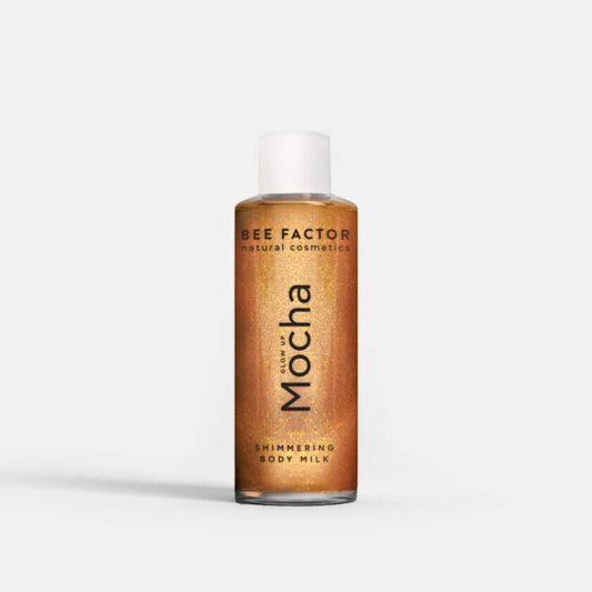 Μπουκάλι Glow Up Mocha Shimmering Body Milk σε λευκό φόντο από την Bee Factor, προσφέρει έντονη ενυδάτωση με bronze λάμψη. Εμπλουτισμένο με πανθενόλη, φυτική γλυκερίνη και aloe vera, αυτό το γαλάκτωμα σώματος θρέφει και ενυδατώνει το δέρμα, αφήνοντάς το απαλό και λαμπερό. Η μοναδική του σύνθεση απορροφάται άμεσα, δεν αφήνει λιπαρότητα και δεν λεκιάζει τα ρούχα. Αρωματίζει απαλά με ένα μεθυστικό καλοκαιρινό άρωμα από άνθη βανίλιας, περγαμόντο και μανόλια. Διαθέσιμο στο Eiria Cosmetics.