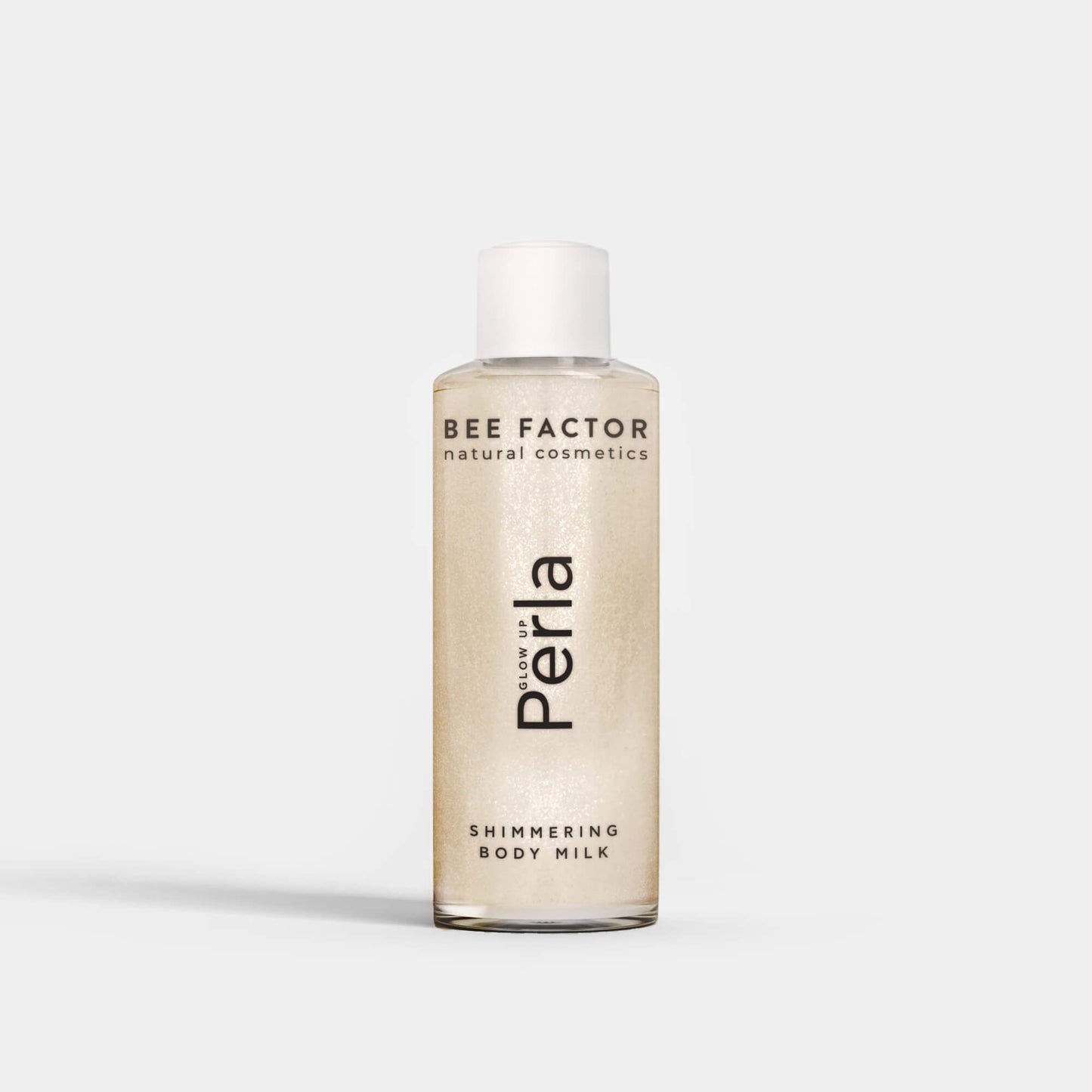 Το Glow Up Perla Shimmering Body Milk της Bee Factor σε διάφανη φιάλη 100 ml με λευκό καπάκι, που αναδεικνύει τη λαμπερή περλέ σύνθεση του προϊόντος. Στην μπροστινή όψη εμφανίζονται το λογότυπο “Bee Factor natural cosmetics”, η ονομασία “Perla” και η ένδειξη “Shimmering Body Milk”. Το προϊόν απεικονίζεται μετωπικά, μόνο του, σε καθαρό ανοιχτόχρωμο φόντο, αποπνέοντας αίσθηση κομψότητας, λάμψης και περιποίησης σώματος.