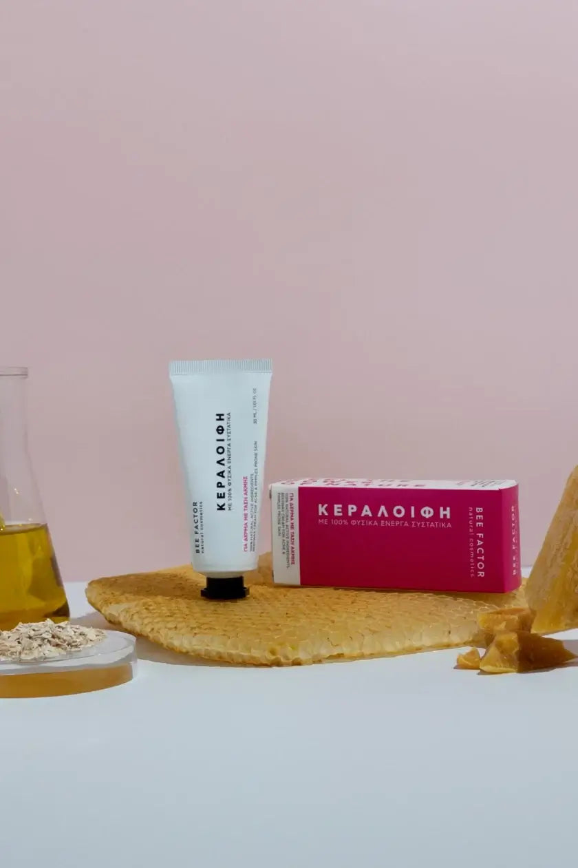 Κεραλοιφή Bee Factor για δέρμα με τάση ακμής, με φυσικά ενεργά συστατικά, ιδανική για σπυράκια και λιπαρή επιδερμίδα — διαθέσιμη στο Eiria Cosmetics. Φωτογραφημένη με κερί, μέλι και βρώμη.