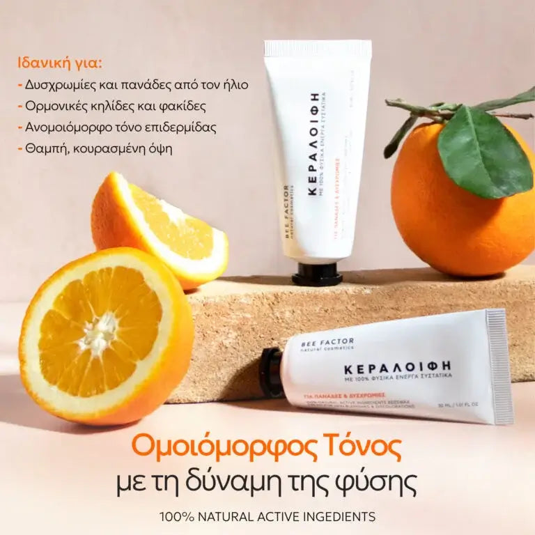 Προωθητική εικόνα της κεραλοιφής Bee Factor με βιταμίνη C για κηλίδες και δυσχρωμίες, με δύο λευκές σωληναριακές συσκευασίες τοποθετημένες σε φυσική σύνθεση μαζί με ολόκληρα και κομμένα πορτοκάλια. Η εικόνα συνδέει οπτικά το προϊόν με τη βιταμίνη C και τη φωτεινότητα της επιδερμίδας, ενώ αναγράφεται ότι είναι ιδανικό για δυσχρωμίες και πανάδες από τον ήλιο, ορμονικές κηλίδες και φακίδες, ανομοιόμορφο τόνο επιδερμίδας και θαμπή, κουρασμένη όψη. Στο κάτω μέρος τονίζεται το μήνυμα «Ομοιόμορφος Τόνος με τη δύνα