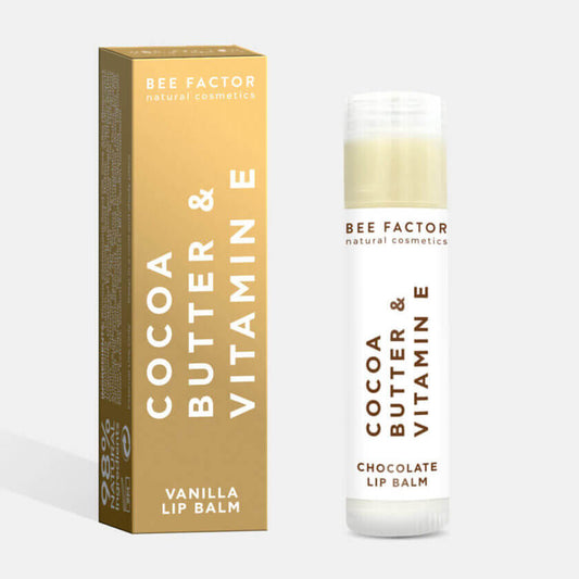 Φυσικό Lip Balm Bee Factor με βούτυρο κακάο και βιταμίνη Ε, σε μορφή stick με λευκή συσκευασία και χρυσό κουτί. Ιδανικό για ενυδάτωση και προστασία των χειλιών με άρωμα βανίλιας, χωρίς parabens. Ιδανικό για ευαίσθητα χείλη – διαθέσιμο στο eiria.gr.