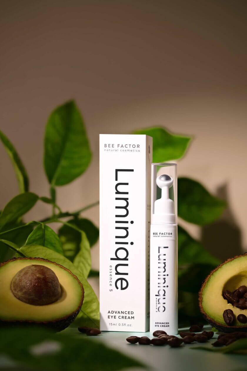 Κρέμα ματιών Luminique της Bee Factor σε πλήρη συσκευασία 15ml, πλαισιωμένη από αβοκάντο και κόκκους καφέ – προηγμένο προϊόν περιποίησης για φωτεινό βλέμμα, διαθέσιμο στο Eiria.