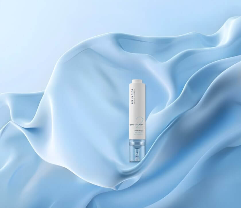 Silky Collagen Face Serum από Bee Factor – ορός προσώπου για ενυδάτωση και ελαστικότητα με φόντο μπλε μεταξωτό ύφασμα, διαθέσιμο στο eiria.gr.